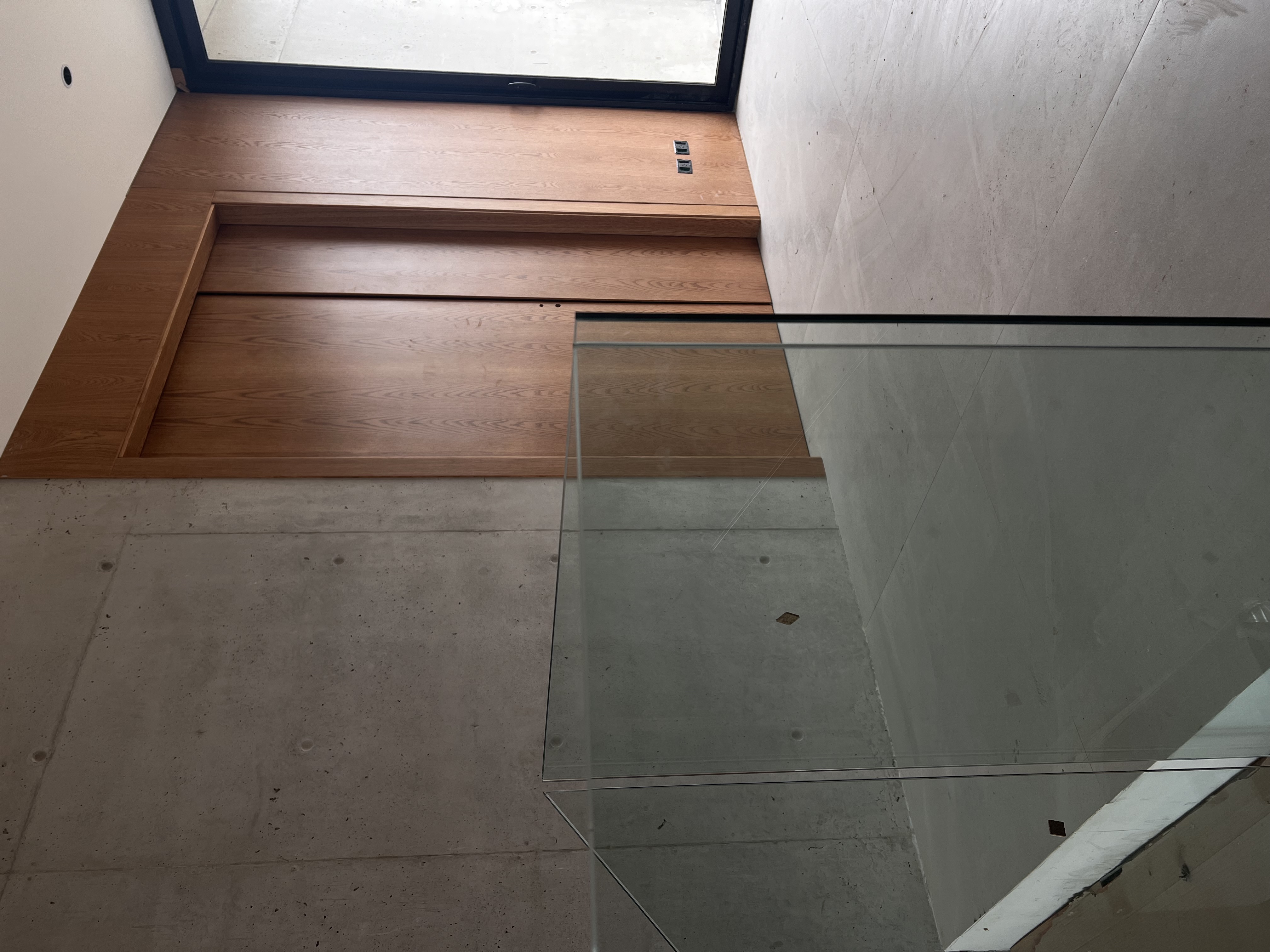 Hall de entrada con vidrio y hormigón casa Riberas