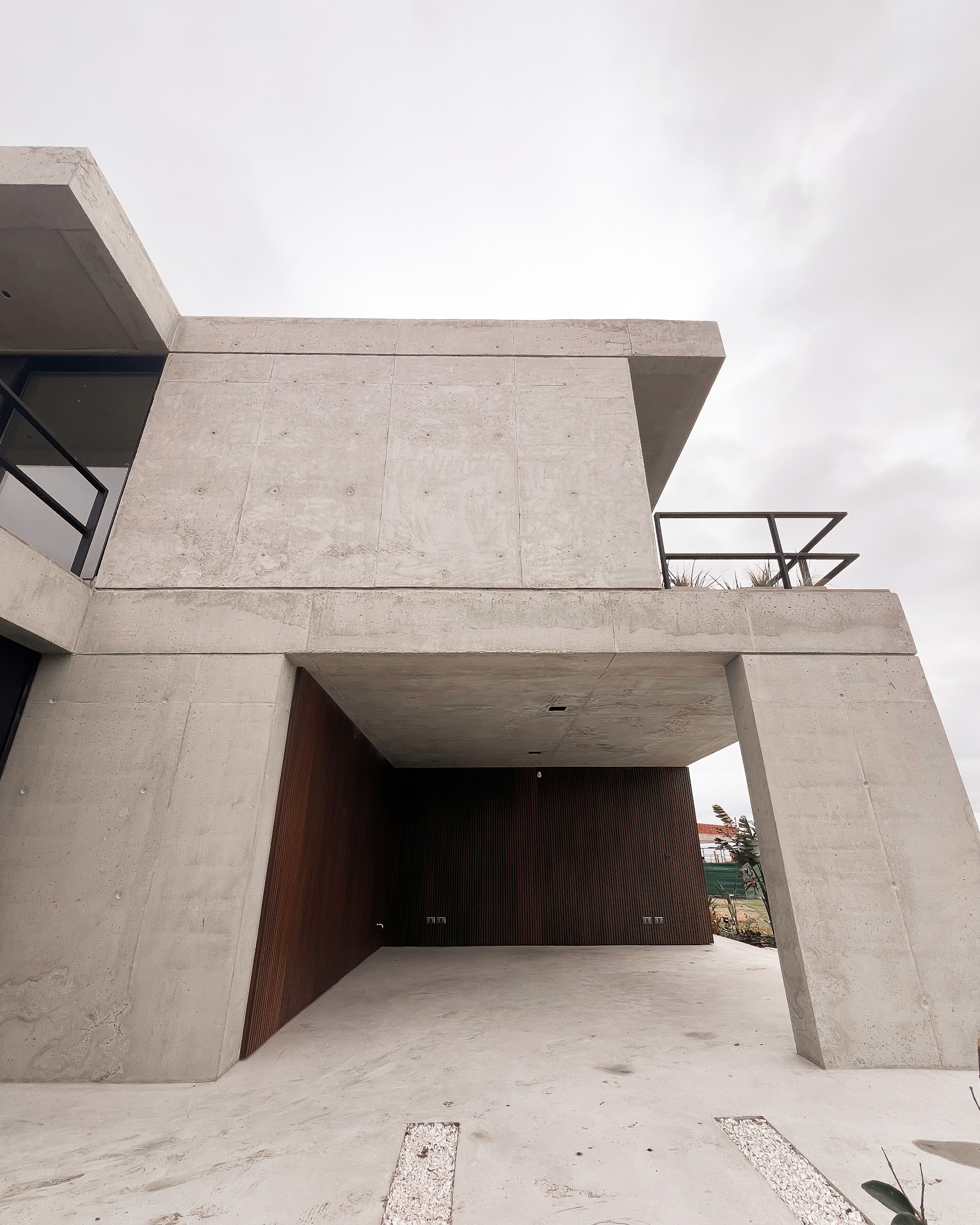 Entrada con hormigón y madera casa Riberas Buenos Aires